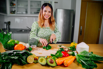 Asian girl cooking healthy vegetarian and vegan food, vegetables and fruits in the kitchen, healthy lifestyle