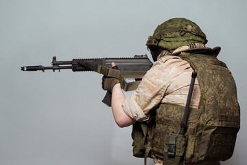 Fototapeta premium Russian military police soldier in desert uniform. Patch on the shoulder flag of Russia, arms of Russian army and the inscription Military Police in Russian. Shot in studio on a grey background.