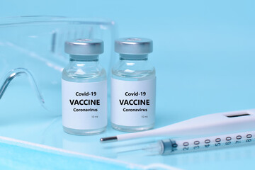 Medical bottles, vials,vaccine, syringe , face mask,body thermometer and protective glasses. The concept of medicine, healthcare, science.Coronavirus vaccine, immunity improvement.Copy space for text.