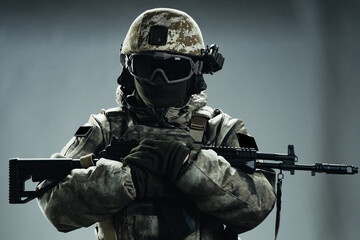 Male special forces soldier in grey winter uniform. Shot in studio on green background.