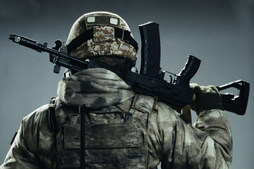 Male special forces soldier in grey winter uniform. Shot in studio on green background.