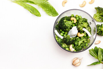 Green peas, broccoli and cashew nuts in blender bowl.