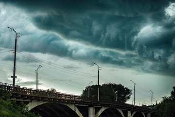 terrible clouds over the city. a sudden change in the weather. a heavy storm and thunderstorm is...