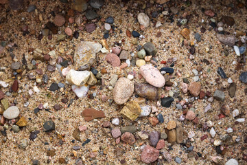 Fototapeta na wymiar Close-up sand with rubble stones. Beige, sand, red, white colors.