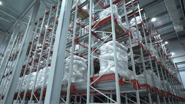 Logistics warehouse. Shelving. White bags on pallets. Cargo. Cargo storage. Transportation services
