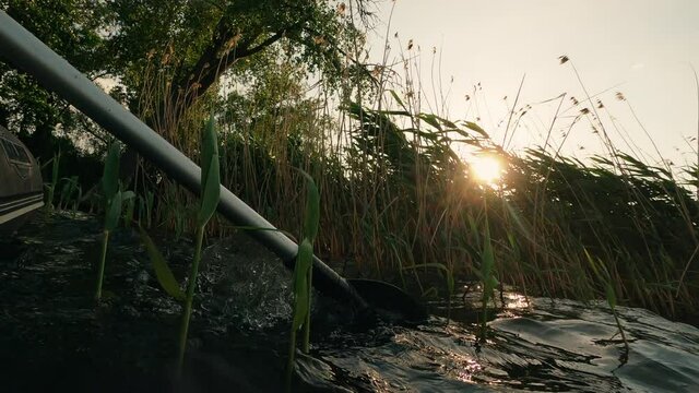Boat paddling. Close nature. Water journey. Enjoy riding. Rubber ship with paddles going on river near rush shore green trees sun flacks lens flare sky horizon.