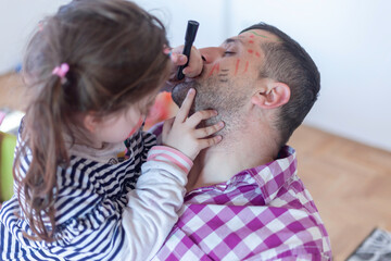 The girl draws her father's face while he sleeps