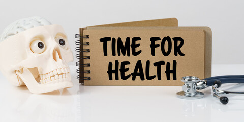 On the table lies a skull, a stethoscope and a notebook with the inscription - TIME FOR HEALTH