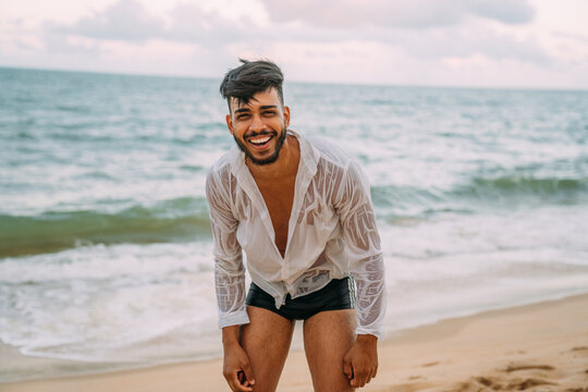 Friendly confident and smiling young latin american man looking at camera on the beach