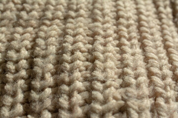 Close-up of a large knitted jumper. English knit. Beige, natural colour.