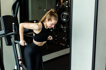 Fototapeta na wymiar Young attractive girl in sportswear in a fitness club. Sports concept.