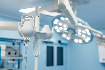 A dropper with medication in the operating room against the background of medical equipment.