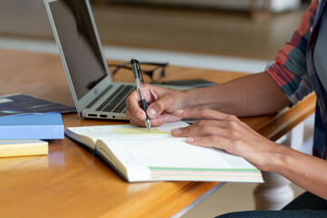 Caucasian woman sitting by desk working from home using laptop