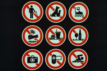 Many prohibition signs on one poster in a summer park. Do not litter, do not smoke, do not drink...
