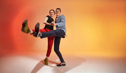 Young nice dancing pair in motion kicks to the camera