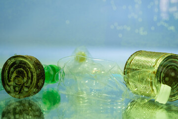 plastic bottles and rusty cans in water, ecology concept