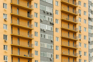 The facade of a multi-storey building with windows and balconies as an element of the architecture of a modern city