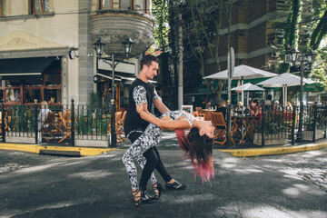 Young hispanic couple dancing Bachata, Salsa on street