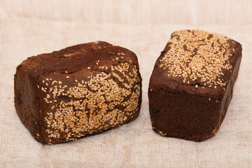 Rye bread. Dessert rye bread with raisins and walnuts in sourdough, sprinkled with sesame seeds. Homemade baking