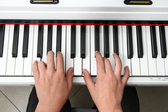 hands playing piano top view