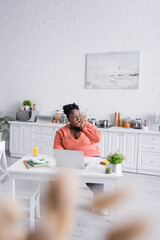 amazed african american plus size freelancer working from home