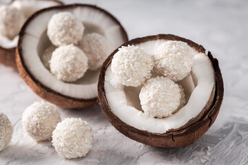 Portions of white chocolate coconut candy balls in raw cracked coconut