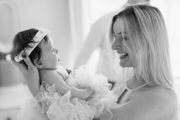 Mom holds her newborn daughter in her arms. The mother is happy with her daughter. Black and White.