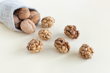 Organic walnuts scattered from a natural bag on a minimal background. Healthy food for the heart, useful microelements and vitamins. Healthy Concept.