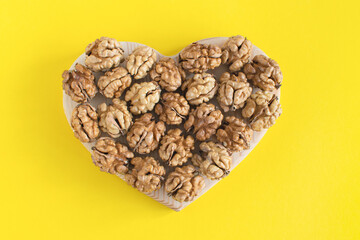 Nuts banner background. Organic walnuts are shaped like a heart on a minimal background. Healthy food for the heart, useful microelements and vitamins. Healthy Concept.