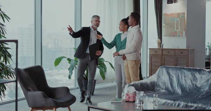 House on sale. Caucasian bearded adult rela estate agent showing new modern apartment home for african american young married couple.