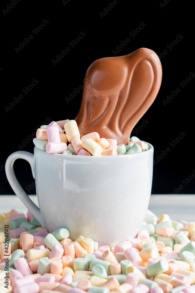 Wall mural Background of spring easter celebration birth festival season with colorful sweet confectionery milk chocolate egg and rabbit bunny ear on marshmallow nest