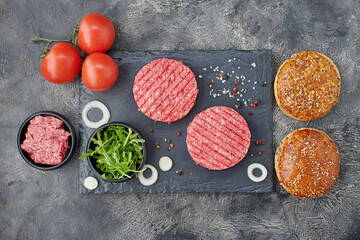 Fototapeta na wymiar Top view of burger ingredients on dark table