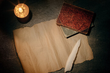 blank sheet of parchment and a pen for writing, antique books and a burning candle, a desk with an...