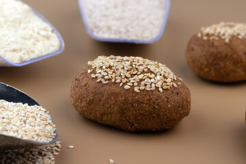 A healthy gluten-free keto bread made from almond flour and psyllium husk, sprinkled with sesame seeds. Baking ingredients in scoops. Ketogenic diet, paleo, low carb, high fat.