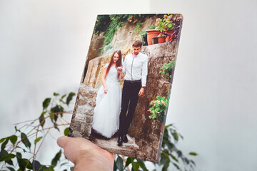 Canvas print stretched on stretcher bar with gallery wrap, hand holds wedding photography