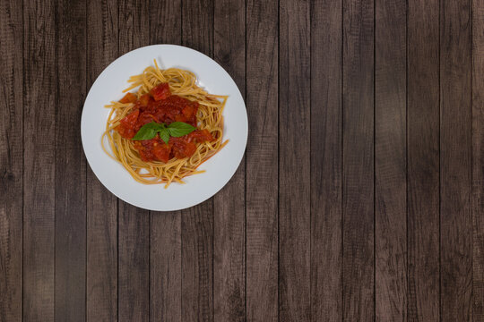 Pasta With Rustic Tomato Sauce And Basil Leaves. Bavette Pasta With Red Sauce. Top View Photo. Bottom And Right Space Of The Photo For Texts.