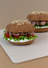 Keto Sandwich with tuna, lettuce, fresh cucumber and tomato slices. The bread is made from almond flour and psyllium. Healthy ketogenic diet menu.