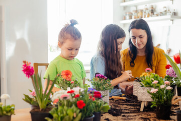 Mother teaches kids to take care of flowers and plants