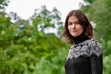 Fototapeta premium Woman wearing a sweater on a green garden background