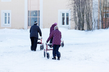 Umea, Norrland Sweden - March 4, 2021: older ladies are out with their walkers in the snow