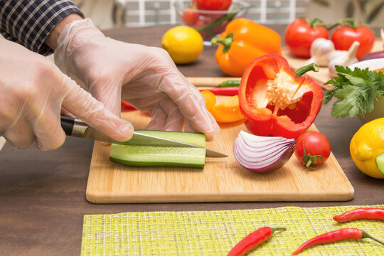 Chef Cutting Cucumber And Vegetables For Salad Close Up. Hands In Gloves Cooking Healthy Vegetarian Vegan Diet Food