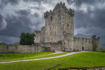 Fototapeta na wymiar Old keep from 15th century, Ross Castle located on the bank of Lough Leane with dramatic storm clouds in background, Ring of Kerry, Killarney, Ireland