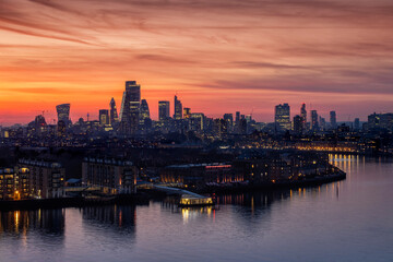 The illuminated skyline of London, United Kingdom, along the Thames River to the City just after sunset during dusk