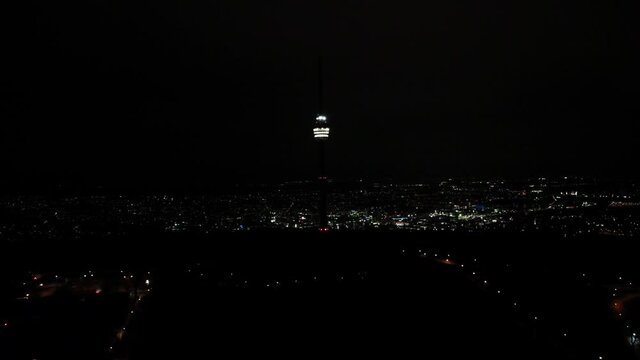 Videoaufnahme vom Fernsehturm Richtung Stuttgart bei Nacht mit Stadtlichtern im Hintergrund des Panorama via Drohne