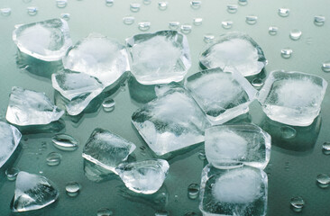 Ice with water drops on refreshing green glossy background