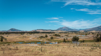Día soleado en el campo con montes de fondo.