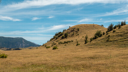 Día soleado en el campo con montes de fondo.