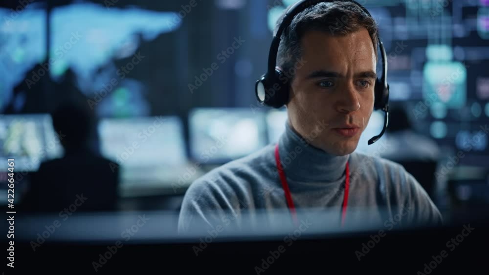Aufkleber Portrait of Professional IT Technical Support Specialist Working on Computer in Monitoring Control Room with Digital Screens. Employee Wears Headphones with Mic and Talking on a Call.