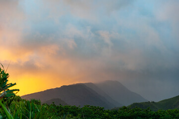 Sunsetting behind the clouds on the mountains of Maui, Hawaii