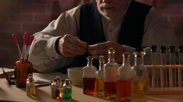 Using a mortar and pestle this scene circa 1800s moves slowly by an apothecary grinding together different herbs and other medicinal dry ingredients.